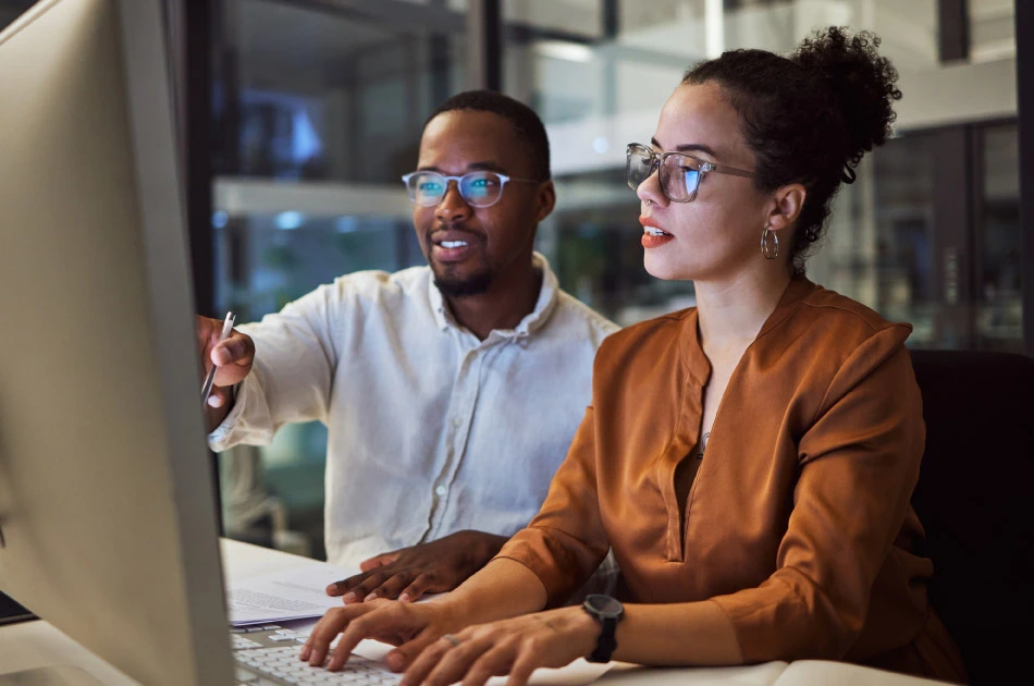 Corporate African man and woman talking about business collaboration during overtime together