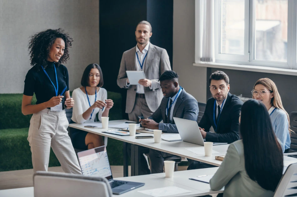 Smiling African female speaker talking to audience during a business conference in office