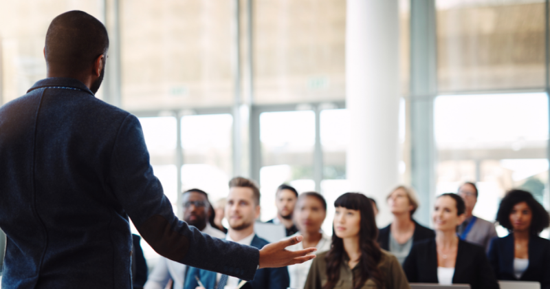 Image_of_business_man_speaking_to_a_group_of_fellow_professionals