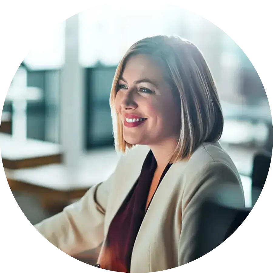 Businesswoman sitting at her desk smiling at computer screen