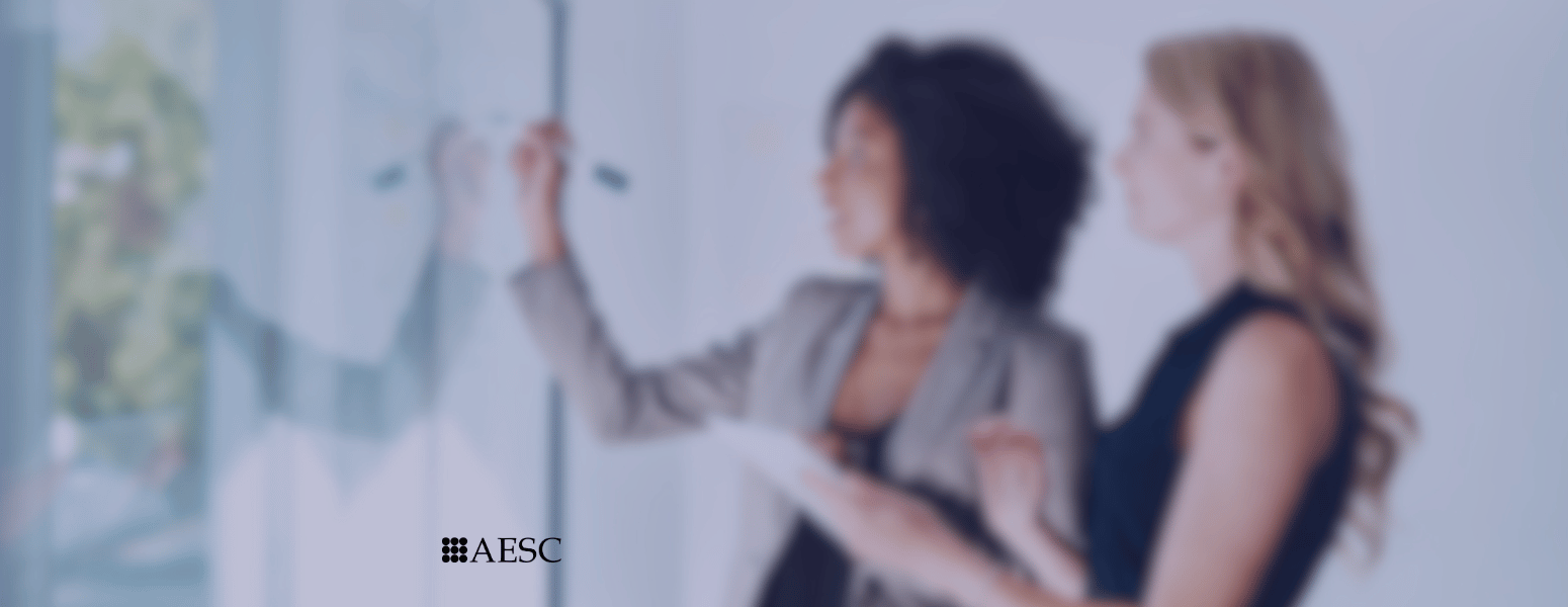 Two professionals strategizing at the whiteboard