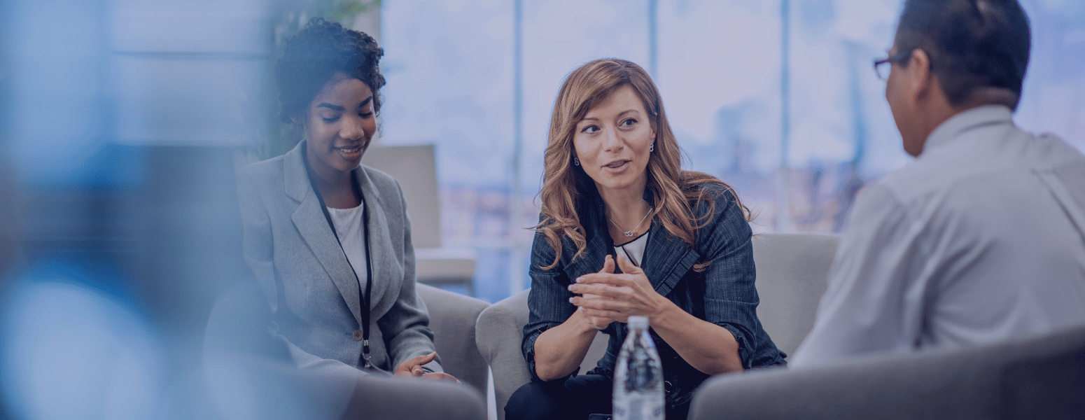 ExecutiveSearchJobs_BlogImage Three professionals sitting in a lounge talking around a coffee table